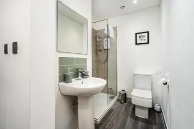 a white bathroom with a sink and a toilet at Renfrew Residence Central Glasgow 4-Bed Flat in Glasgow