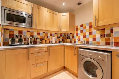 a kitchen with a washing machine and a microwave at amazing apartments - Torphichen Place by Haymarket in Edinburgh