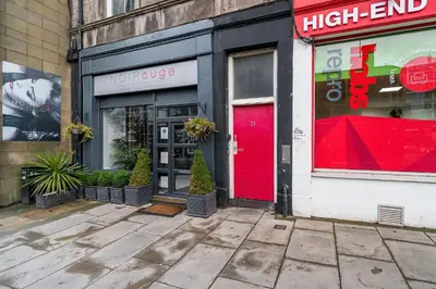 a high end store with a red door on a street at amazing apartments - Torphichen Place by Haymarket in Edinburgh