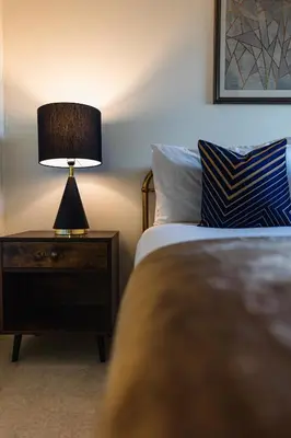 a bedroom with a bed and a lamp on a nightstand at The Skyline Suite - *Private Balcony* *Views* in Glasgow