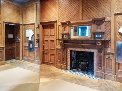 a living room with a fireplace and wooden walls at Kilbowie Retreat in Oban