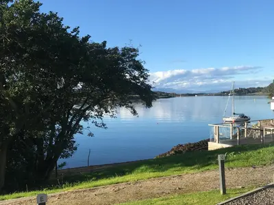 a sailboat is docked at a dock on a lake at Kilbowie Retreat in Oban