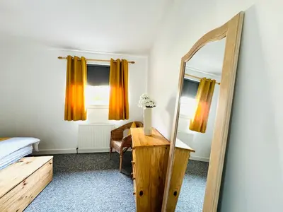 a mirror in a bedroom with a bed and a desk at Tillicoultry Jupiter Apartment - Scotland Holiday Let in Tillicoultry