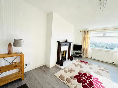 a bedroom with a fireplace and a bed with a rug at Tillicoultry Jupiter Apartment - Scotland Holiday Let in Tillicoultry