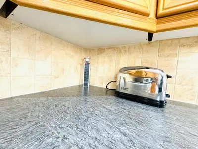 a toaster sitting in a room with a tile wall at Tillicoultry Jupiter Apartment - Scotland Holiday Let in Tillicoultry
