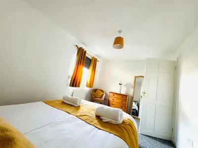 a bedroom with a bed with two towels on it at Tillicoultry Jupiter Apartment - Scotland Holiday Let in Tillicoultry