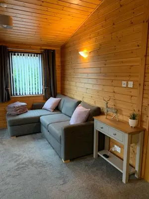 a living room with a couch and a table at Corrie Lodge, Glendevon in Glendevon
