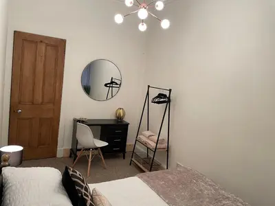 a bedroom with a bed and a desk and a mirror at Heart of George street / Oban / Argyll in Oban