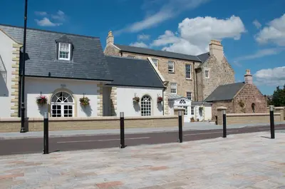 a row of buildings with flowers on the windows at Dumfries Arms Hotel in Cumnock