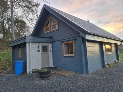 a blue tiny house with a white door at Alban in Linlithgow