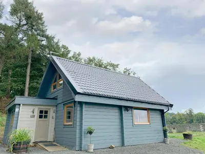 a blue tiny house with a door at Alban in Linlithgow