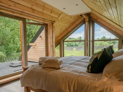 a large bed in a room with a large window at Alban in Linlithgow