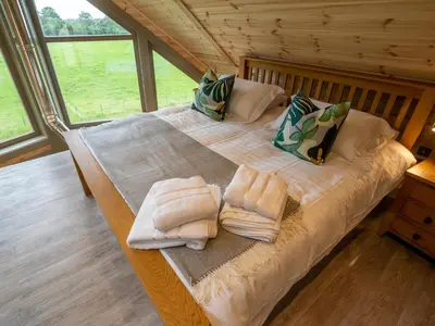 a large bed in a room with towels on it at Alban in Linlithgow