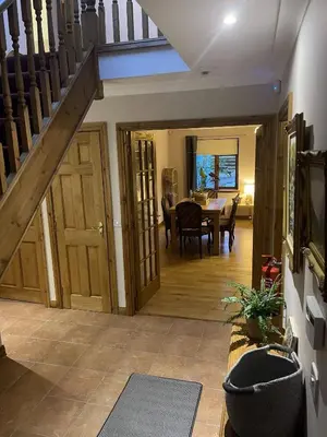 a living room with a staircase and a dining room at Foxglove Cottages in Drymen