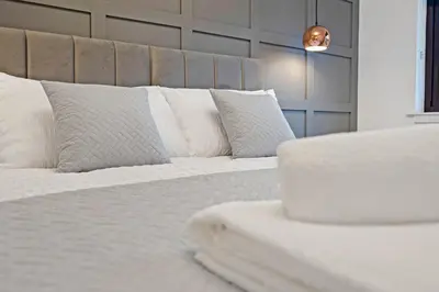 a bedroom with a white bed with pillows at Pitcorthie House in Dunfermline