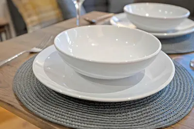 a table with two white bowls and plates on it at Pitcorthie House in Dunfermline