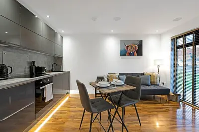 a kitchen and living room with a table and chairs at Pitcorthie House in Dunfermline