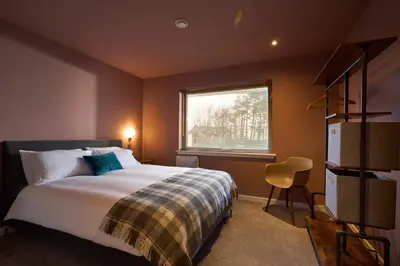 a bedroom with a bed and a window at Tanamuir, overlooking Loch Fyne, Strachur in Cairndow