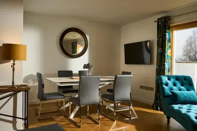 a dining room with a table and chairs and a mirror at Tanamuir, overlooking Loch Fyne, Strachur in Cairndow