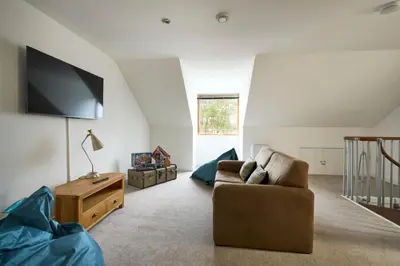 a living room with a couch and a flat screen tv at Tanamuir, overlooking Loch Fyne, Strachur in Cairndow