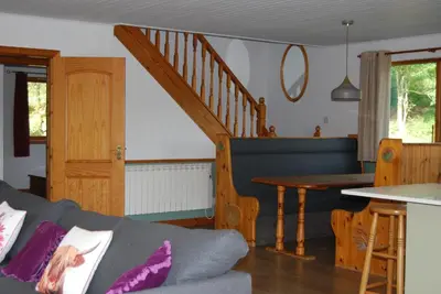 a living room with a couch and a table at Ghillies Lodge Crianlarich in Crianlarich