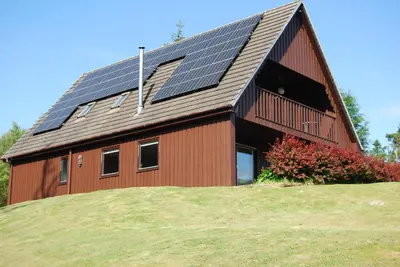 a barn with solar panels on the roof at Ghillies Lodge Crianlarich in Crianlarich