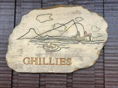 a sign on a wooden wall that says chilliates at Ghillies Lodge Crianlarich in Crianlarich