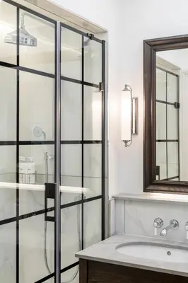 a bathroom with a glass shower and a sink at RÌGH Residences - George Street in Edinburgh