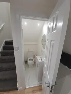a white bathroom with a toilet and a staircase at Modern house close to Glasgow Green in Glasgow
