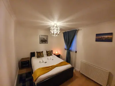 a bedroom with a bed and a chandelier at Modern house close to Glasgow Green in Glasgow