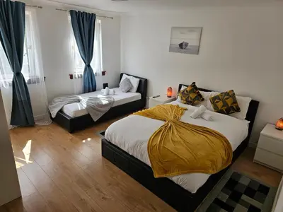a bedroom with two beds with blue curtains at Modern house close to Glasgow Green in Glasgow