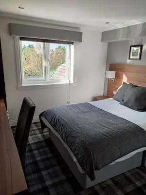 a bedroom with a large bed and a window at Mango the Hotel in Haggs