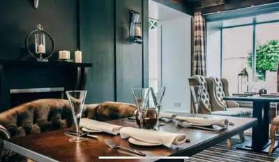 a dining room with a wooden table with glasses on it at Mango the Hotel in Haggs