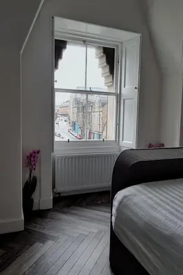 a bedroom with a bed and a large window at Castle Terrace 1 Bed Apartment Looking onto Edinburgh Castle - Sleeps upto 4 in Edinburgh