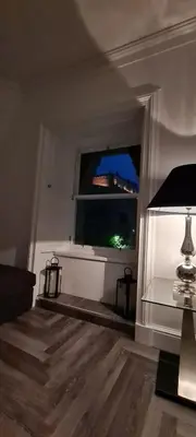 a living room with a window and a table with a lamp at Castle Terrace 1 Bed Apartment Looking onto Edinburgh Castle - Sleeps upto 4 in Edinburgh