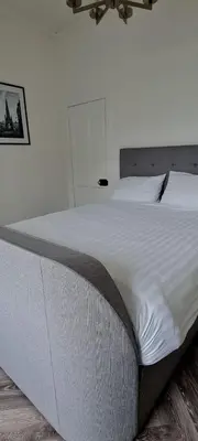 a large white bed in a white bedroom at Castle Terrace 1 Bed Apartment Looking onto Edinburgh Castle - Sleeps upto 4 in Edinburgh