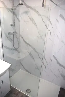 a shower with a glass door in a bathroom at Kelpies Serviced Apartments- Robertson in Falkirk