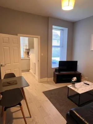 a living room with a couch and a table at Kelpies Serviced Apartments- Robertson in Falkirk