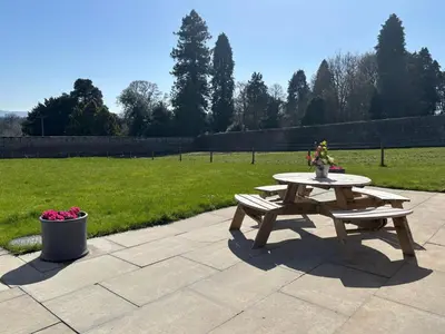 a picnic table and two benches on a patio at Cosy Country Modern Studio with Patio Space. in Crieff