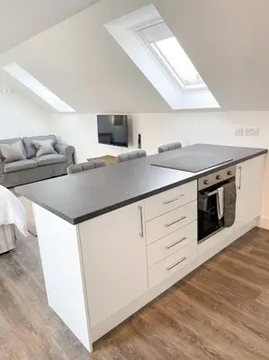 a kitchen with a white island with a counter top at Cosy Country Modern Studio with Patio Space. in Crieff