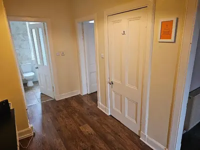 an empty hallway with a toilet and a door at Snug - Abhainn Apartment in Helensburgh