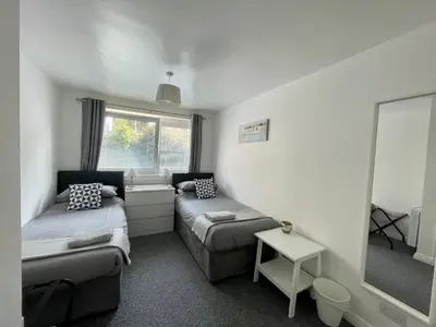 a small room with two beds and a mirror at Dalriach Apartment in Oban