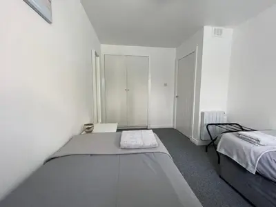 a white room with two beds in it at Dalriach Apartment in Oban