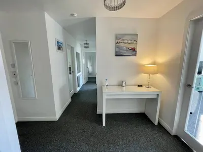 a hallway with a white table in a room at Dalriach Apartment in Oban