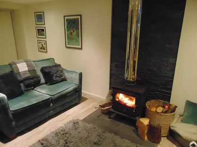 a living room with a couch and a fireplace at Dreamwood Cottage, Loch Lomond, Luxury Apartment. in Glasgow