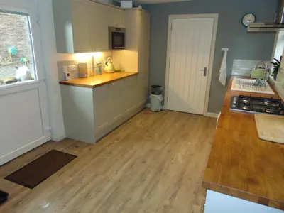 a kitchen with a counter top and a wooden floor at Dreamwood Cottage, Loch Lomond, Luxury Apartment. in Glasgow
