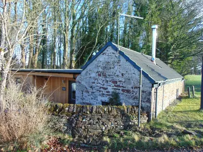 a small stone building with a slate roof at Dreamwood Cottage, Loch Lomond, Luxury Apartment. in Glasgow