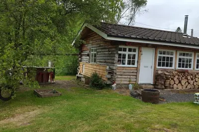 a log cabin with a white door at Pine Cabin, Strathyre. A cosy escape from it all. in Strathyre