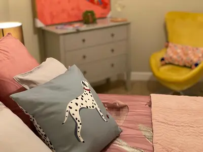 a bed with a pillow with a giraffe on it at Lovely 3 bed with jacuzzi, close to airport, driveway, wifi in Edinburgh