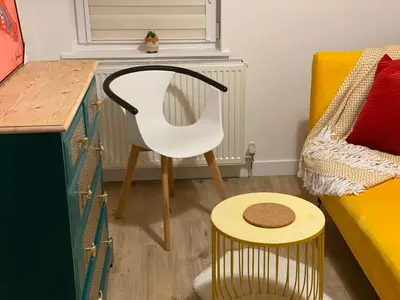 a bedroom with a white chair and a table at Lovely 3 bed with jacuzzi, close to airport, driveway, wifi in Edinburgh